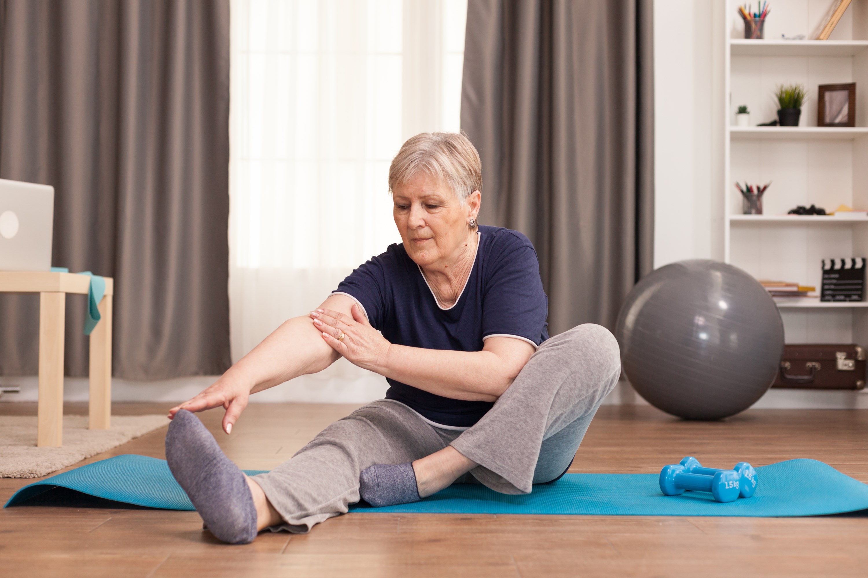 active-old-woman-exercising-yoga-mat-her-comfortable-apartment