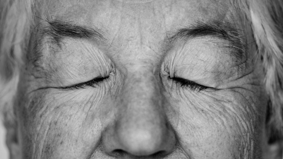 black-white-portrait-white-elderly-woman-eyes-closed