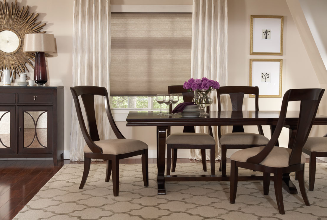 Lightly colored tan Parasol® Continuum Cord Loop Shades with Custom Interior Masterpieces® Draperies in a dining room with dark wood chairs and table