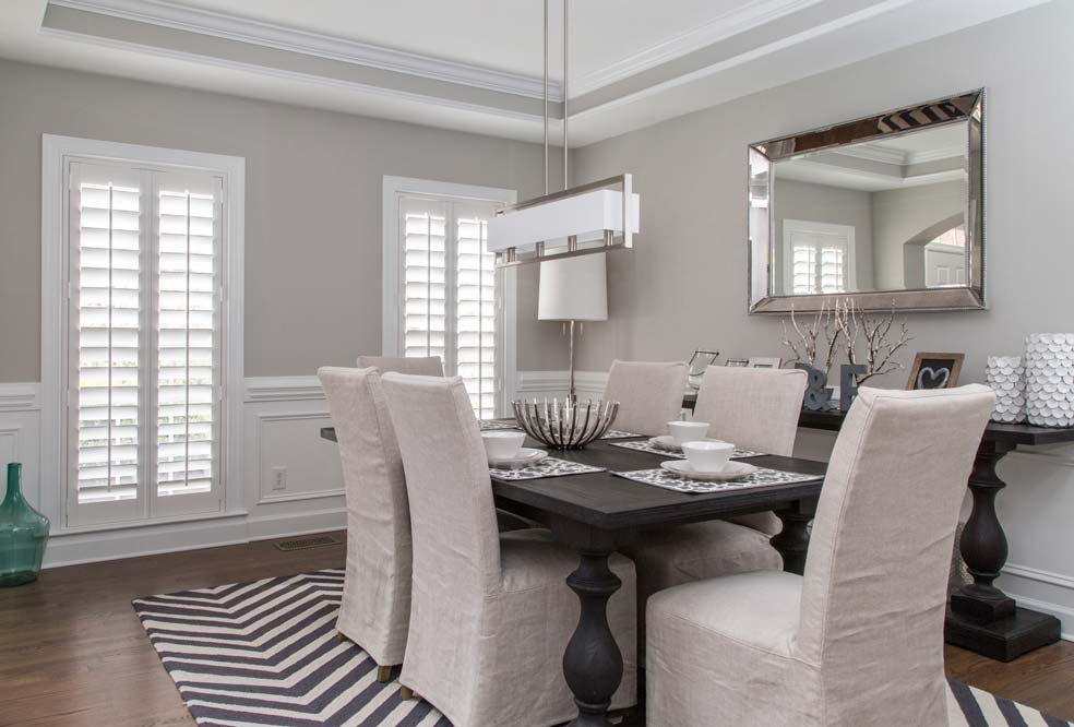 white Parke® Shutters in a kitchen with a black table and light gray chairs