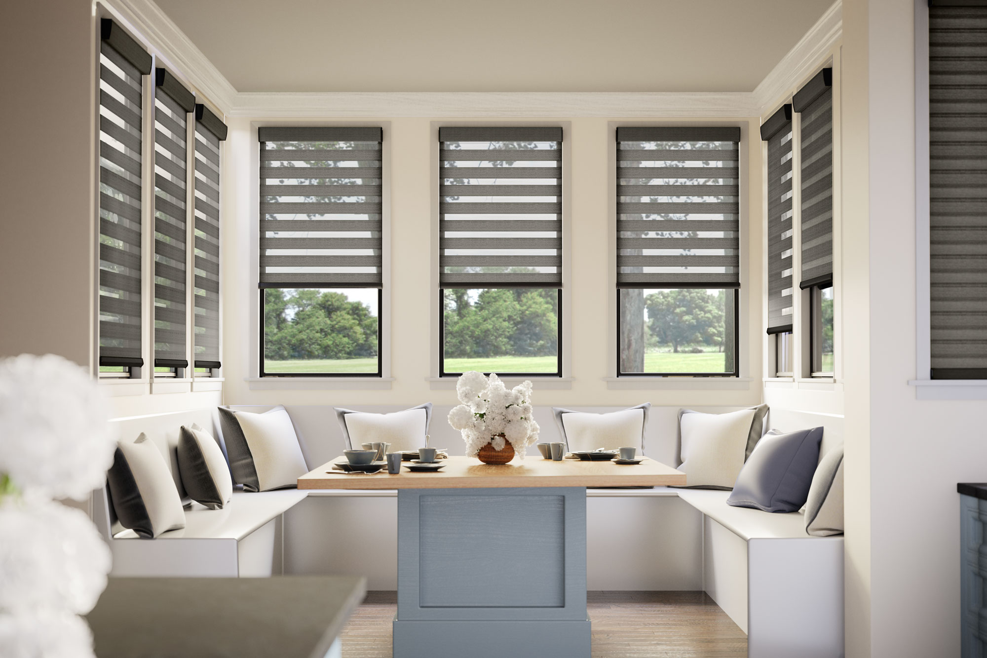 Several darker Allure® Transitional Shades in a nook area with a wrap around white bench and several white and dark colored pillows