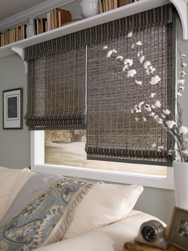 wide dark colored Manh Truc® Woven Wood Shades 2-on-1 with custom banding behing a cream colored couch