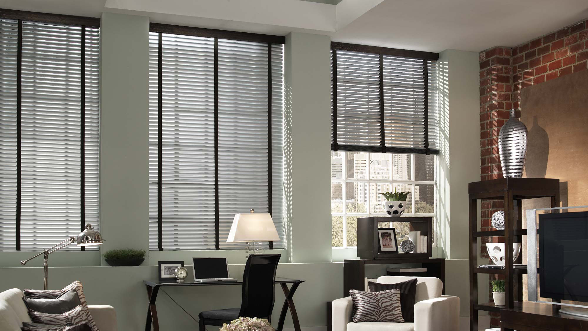 Dark Classic Collection® Aluminum Blinds with Embellishment Trim Banding in an office with a chair that has Interior Masterpieces® Custom Pillows