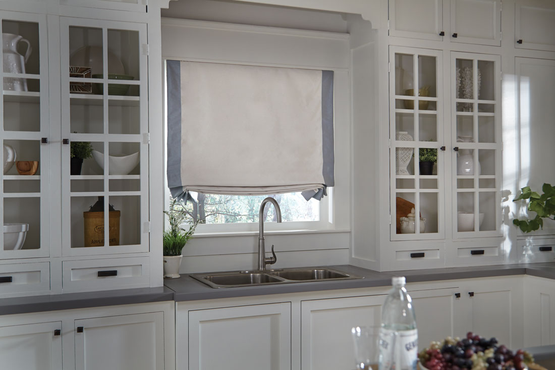 Tan Interior Masterpieces® fabric shade with accenting light blue banding on each side in a kitchen behind a sink