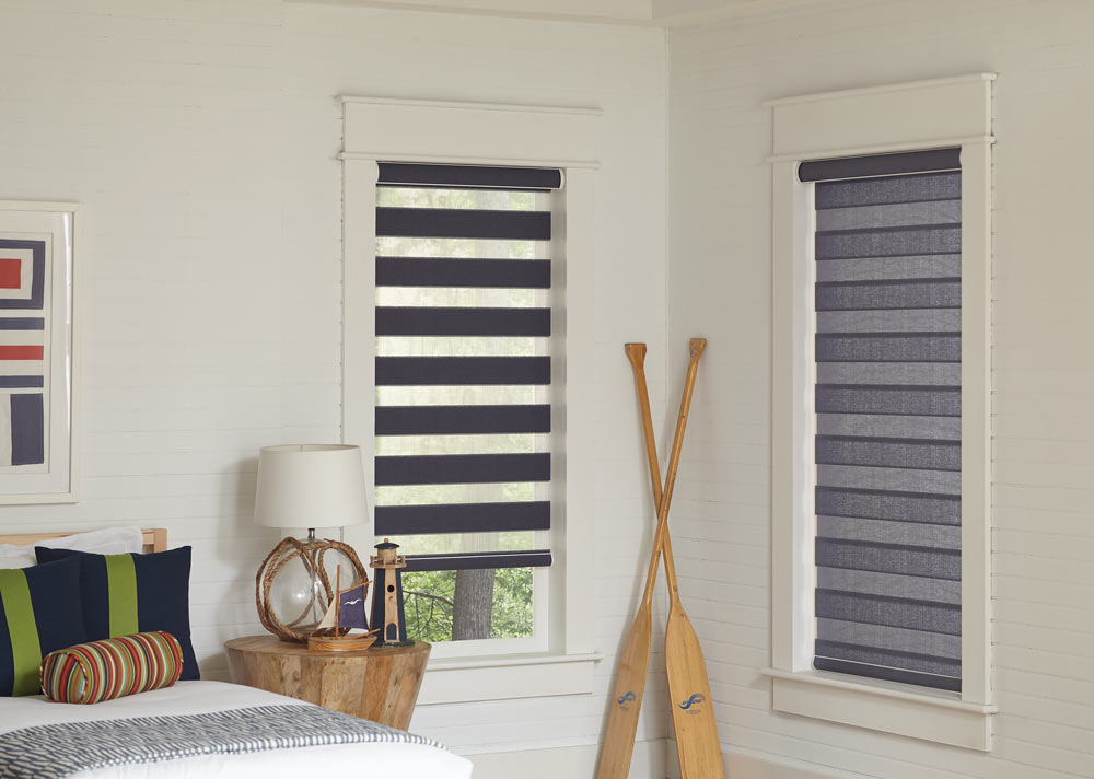 Two light gray Allure® Transitional Shades in a bedroom with oars leaning on the wall in between them