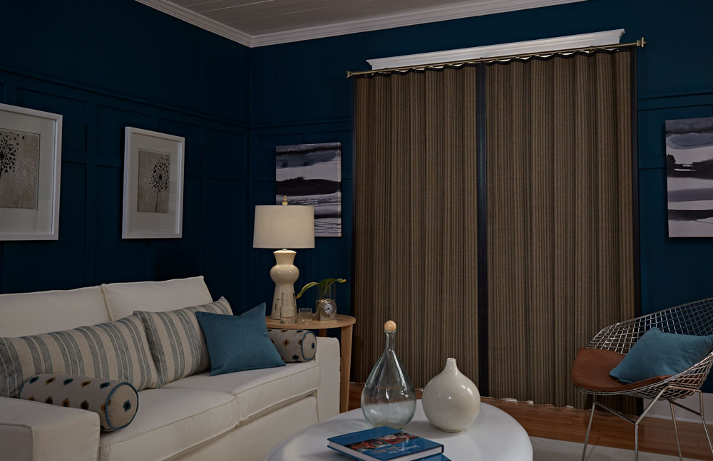 Dark brown Manh Truc® panel drape in a room with blue walls a white couch and accenting Interior Masterpieces® pillows