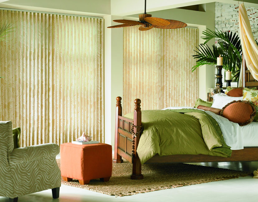 2 Sheer Visions® Vertical Blinds hanging in windows with a bed that has custom bedding and pillows from Interior Masterpieces®