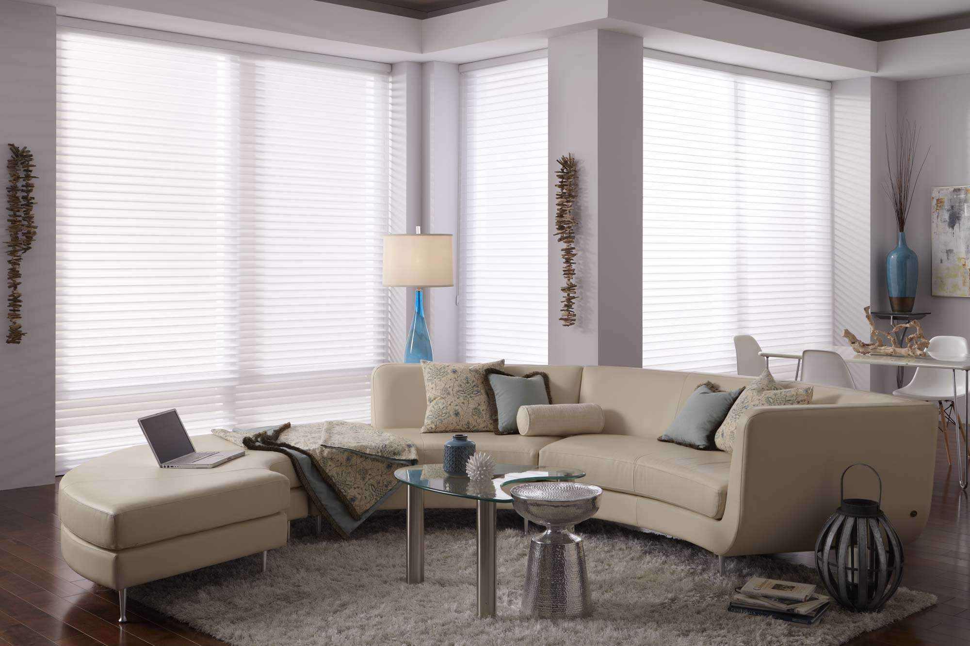 3 Large white Tenera® Sheer Shades hanging in a room with a large tan couch with custom Interior Masterpieces® pillows and throws