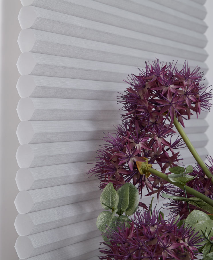 A side view of the Cells in a white Parasol® Cellular material with a purple flower in front