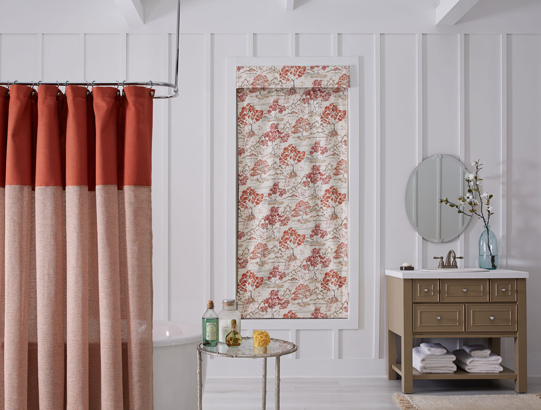 tan and red floral patterened Interior Masterpieces® fabric shade with matching fabric cornice in a bathroom with a red and light red shower curtain