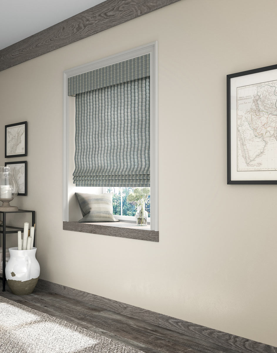 Blue and white Manh Truc® Woven Wood Shades against a tan wall with dark gray wood floors