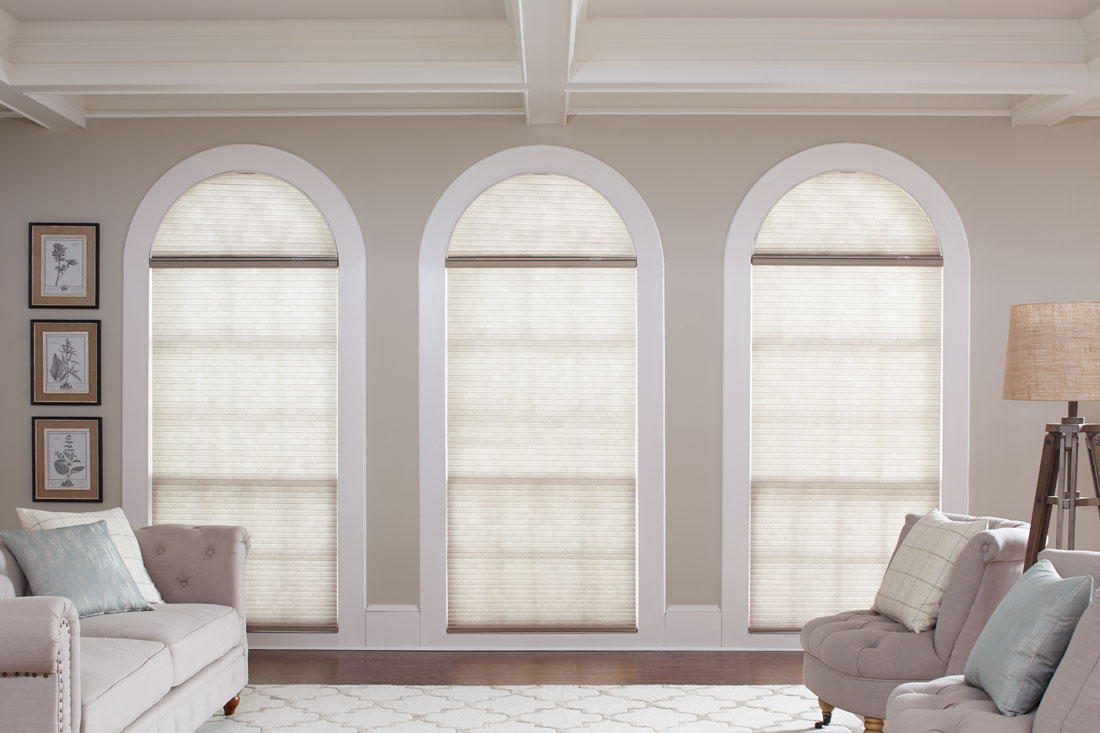 Three Parasol® Cellular shades in 3 tall windows with a rounded top that have Slide Arch Specialty Shaped Parasol® shades in them