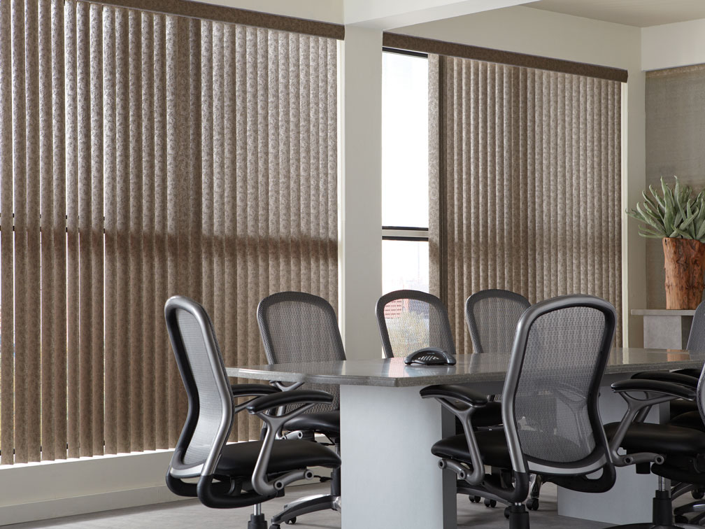 Brown Discoveries® Vertical Blinds in an office with gray chairs and desk in front