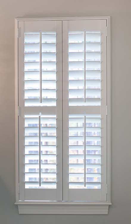 closeup view of Parke® Shutters in a window with a divider rail