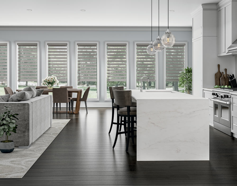 several light brown Allure® Transitional Shades in a dining area with a brown table and chairs that has white flowers on it with more seating and a kitchen in the foreground