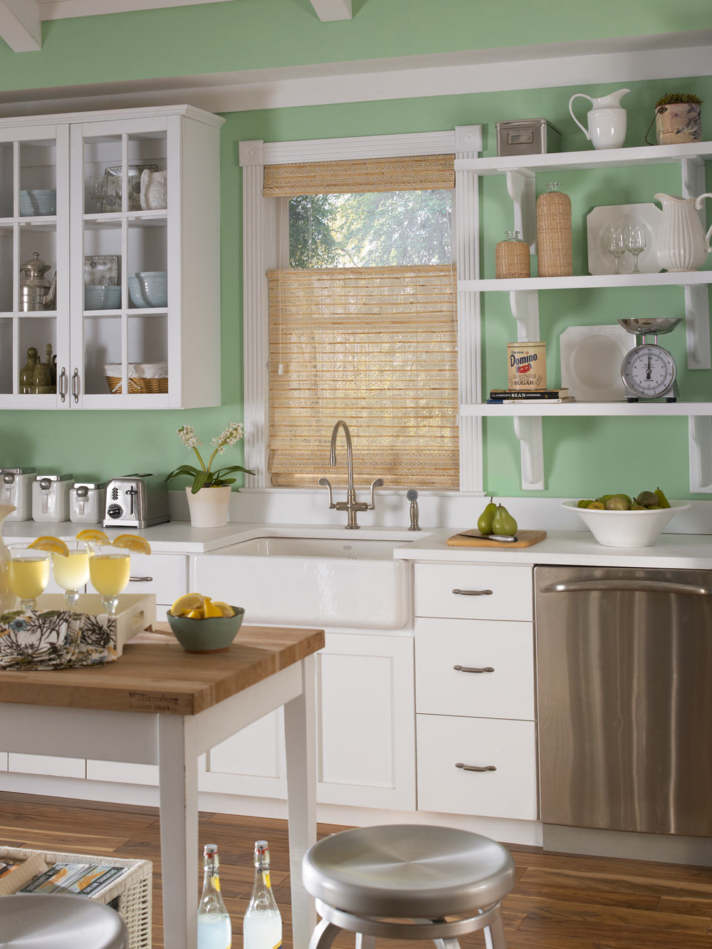 Light brown Manh Truc® Woven Wood Shade against light green walls in a kitchen