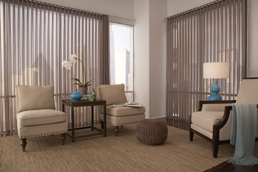 Brown colored Sheer Visions® vertical blinds in two large picture windows with tan furniture in the room