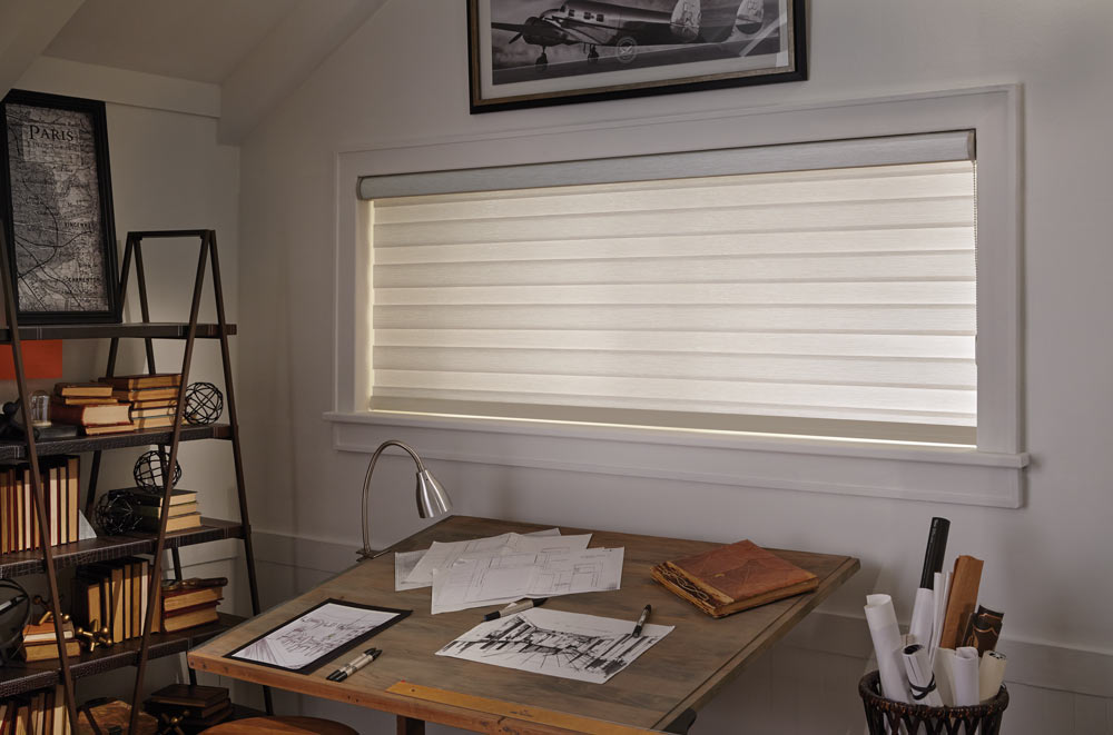 Cream colored wide Allure® Transitional Shade behind a desk with art supplies on it