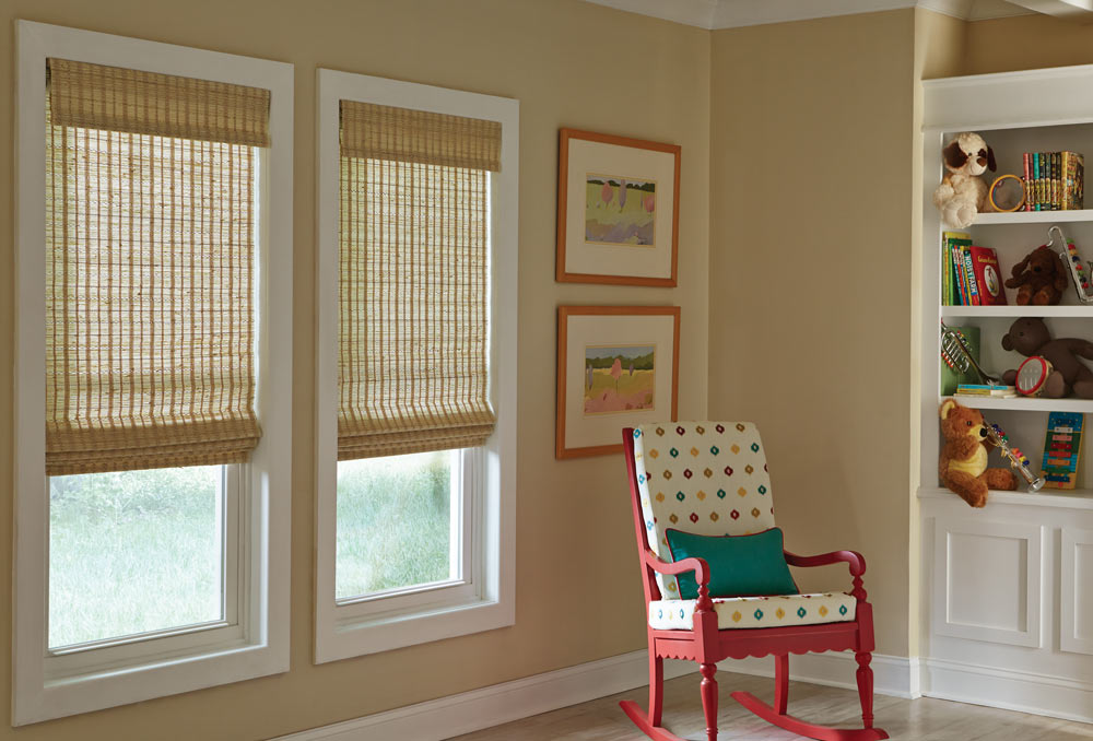 two light brown Manh Truc® Woven Wood Shades behind a polka dot and pink chair