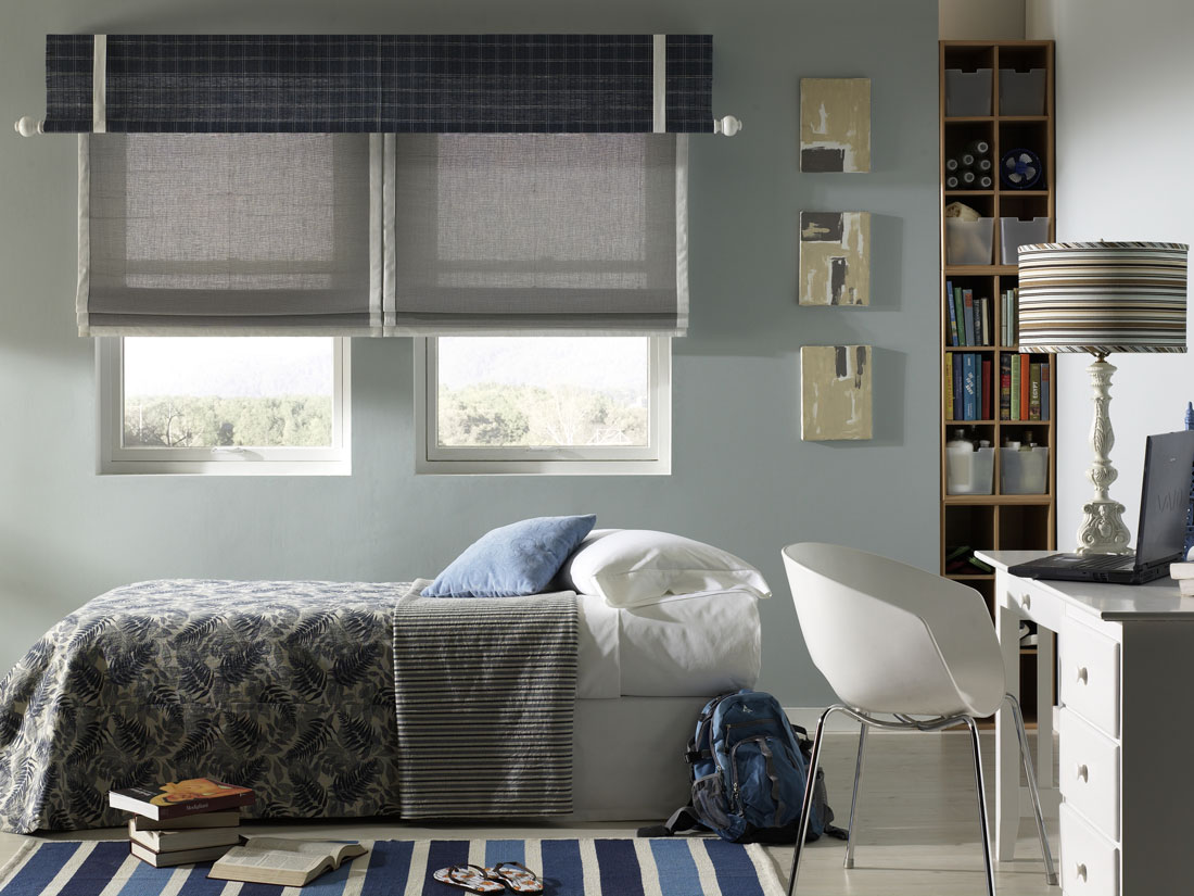 Gray Manh Truc® woven wood shades with white banding and a blue plaid Interior Masterpieces® Valance that has a white custom rod with finals