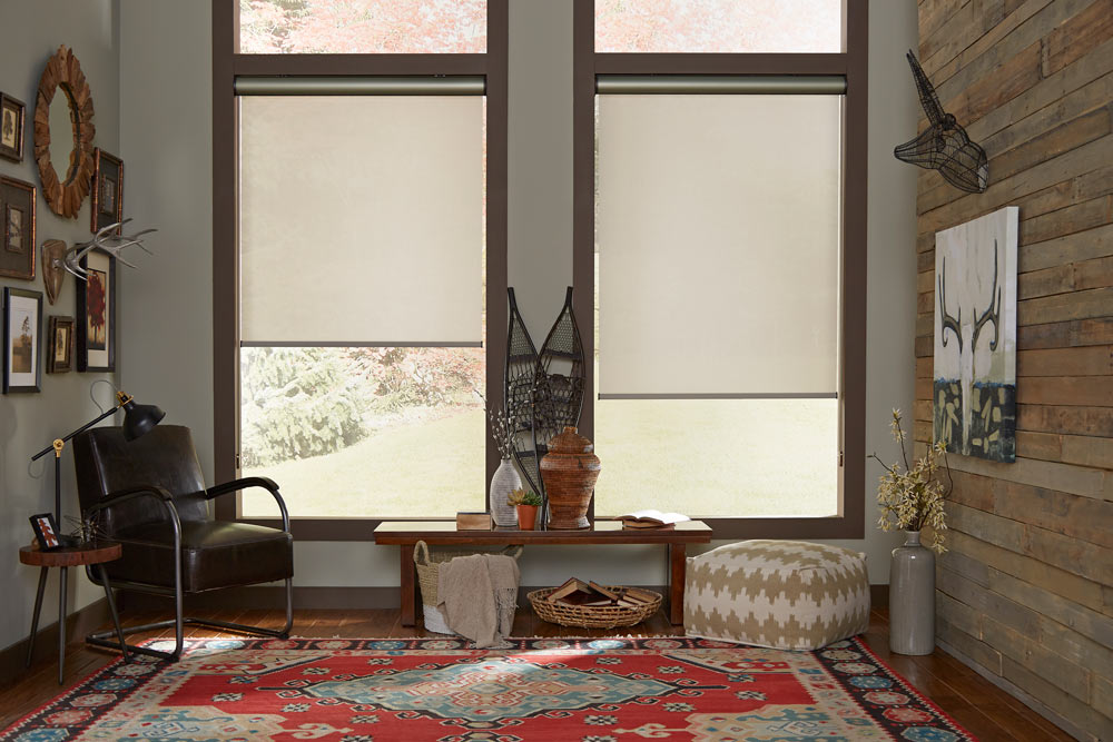 two large tan Genesis®  Roller Shades with bronze Cassettes in a room with gray walls and dark brown trim