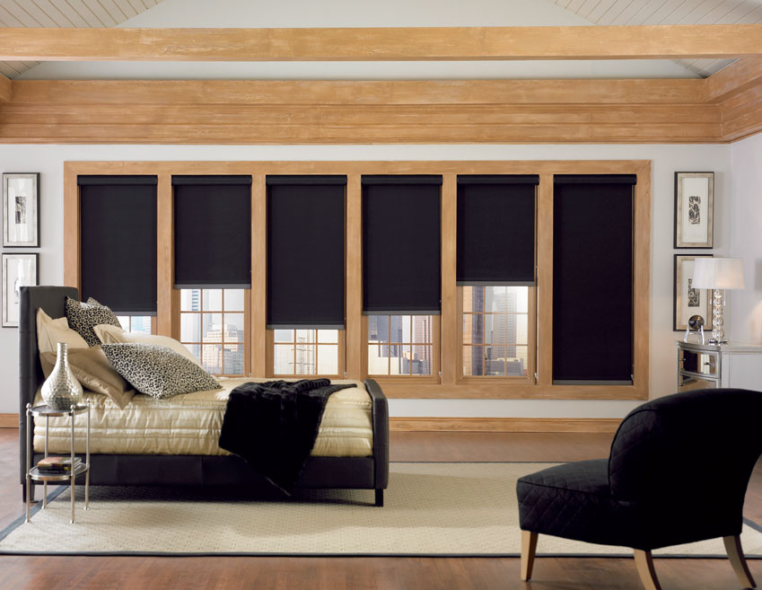 A bedroom wall of windows with black Genesis® Custom Roller Shades