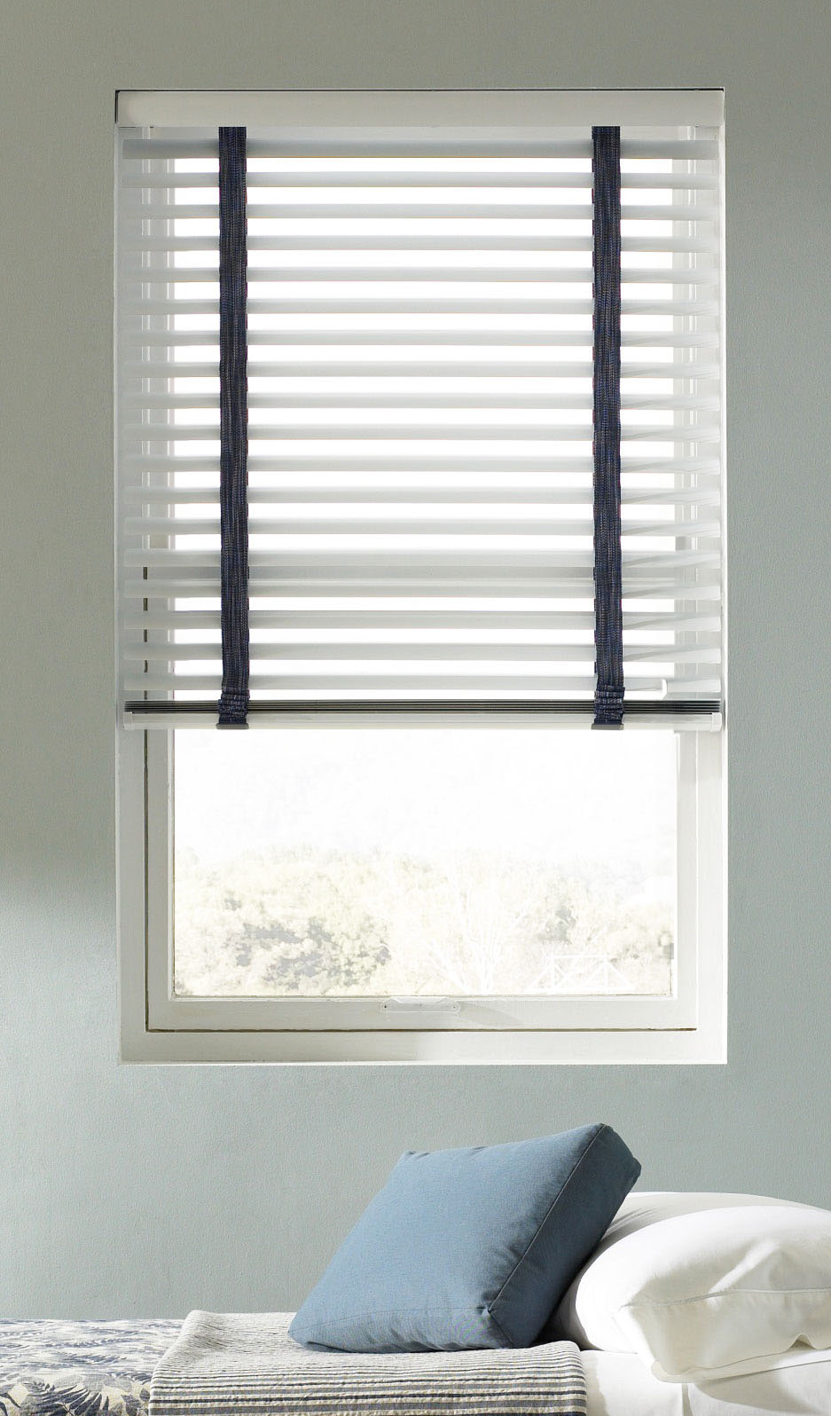 White Classic Collection® Aluminum Blinds with blue ladders against a light blue wall in a bedroom