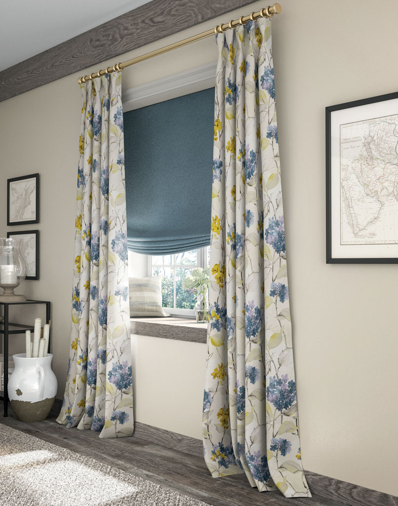 blue Interior Masterpieces® fabric shade with white, blue, and yellow floral pattern draperies hanging in a window with a custom pillow and flowers