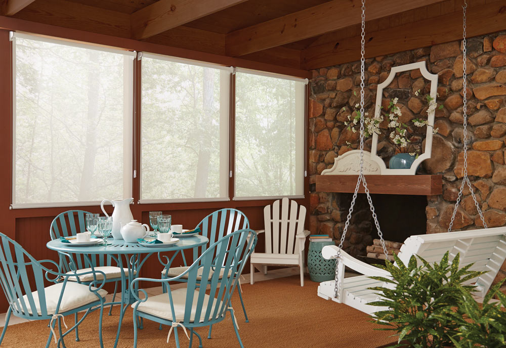 three large Genesis® Custom Roller Shades in a cabin with blue and white furniture in the foreground