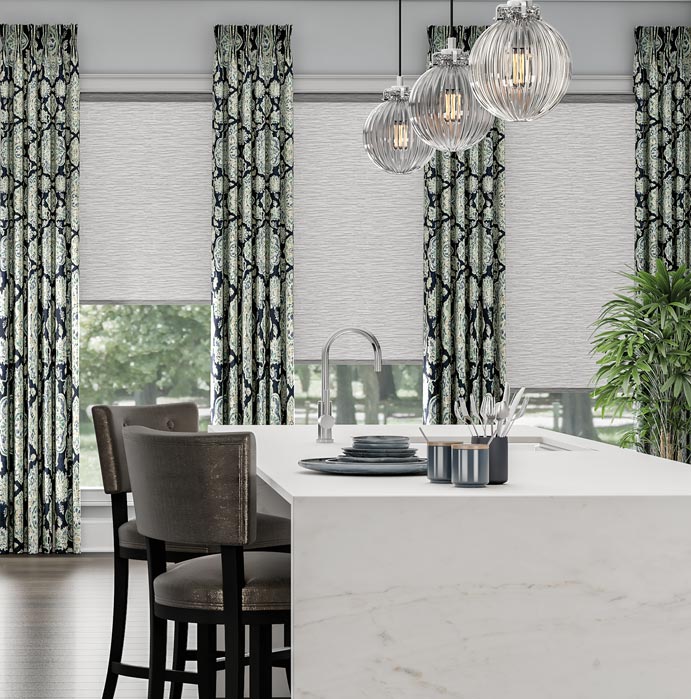 Three white Genesis® Roller Shades with drapery panels from Interior Masterpieces® in a kitchen setting