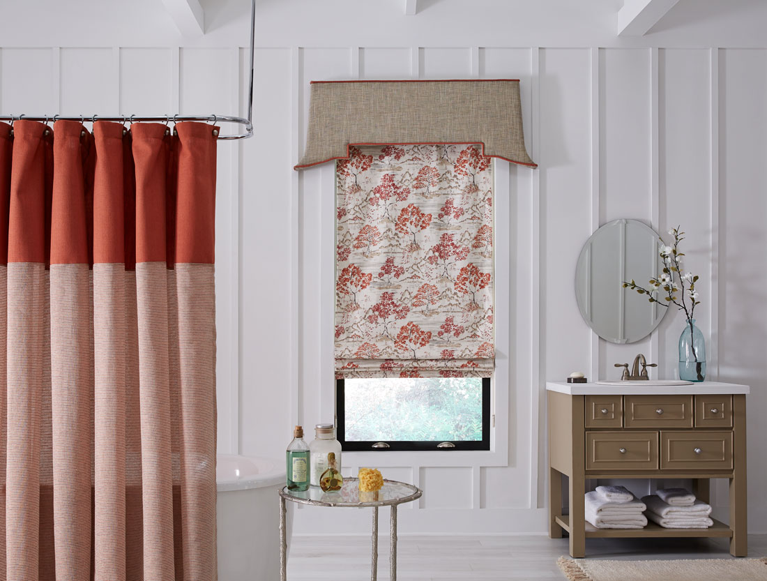 Red and white floral patterned Interior Masterpieces® shade with tan Cornice in a bathroom with a red shower curtain