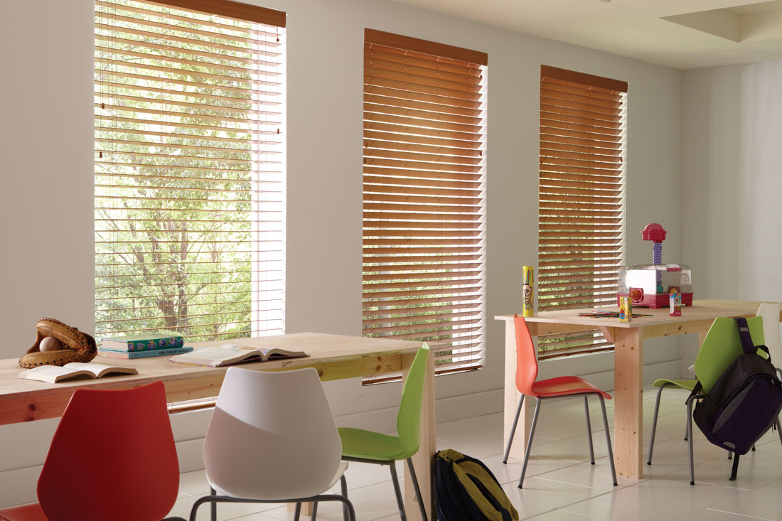 light brown Wonderwood® Wood Blinds in a classroom with multiple colorful chairs