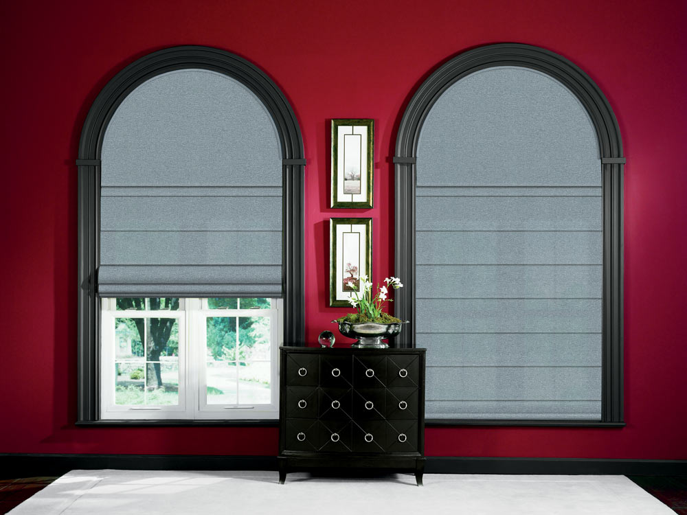 two large gray Genesis® Hobbled Roman Shades half cirlce Custom Shapes above with black window trim and red walls