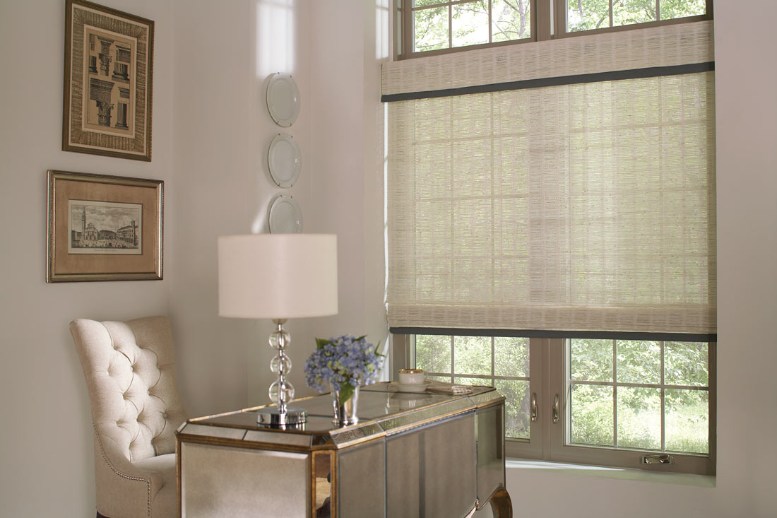 White Manh Truc® Woven Wood Shades with blue Custom Banding behing a table with a lamp and a light colored chair in the corner