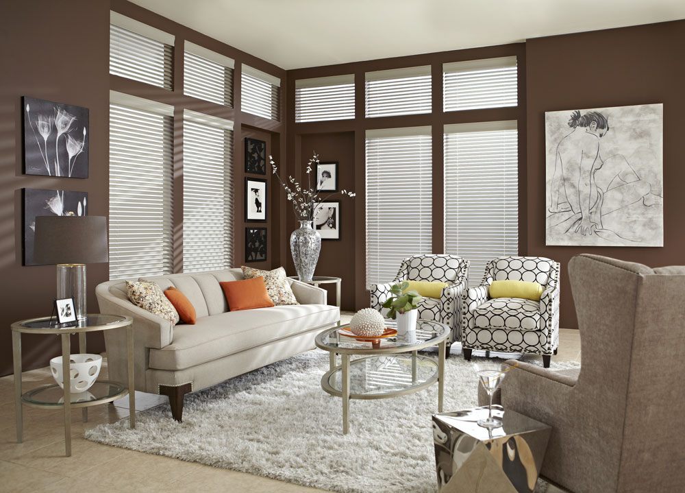 Several white Heartland Woods® Wood Blinds & Interior Masterpieces® Custom Pillows on a white couch and chairs with circular geometric patterns