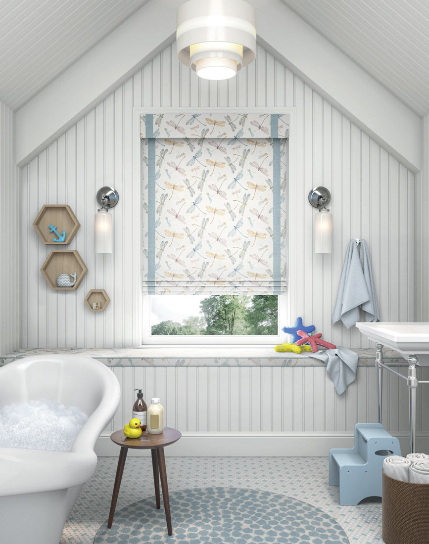 a light Manh Truc® Woven Wood Shade with a dragonfly pattern and light blue decorative banding in a bathroom with a bath tub full of suds