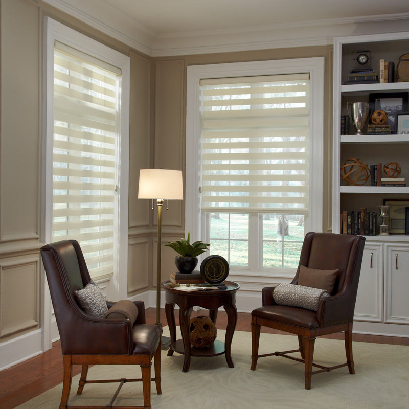 two cream colored Allure® Transitional Shades on a room behind a small dark desk with matching chairs