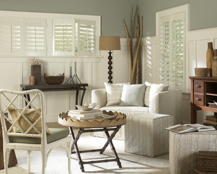 several white Parke® Shutters in a living area with a couch that has Interior Masterpieces® Custom Pillows