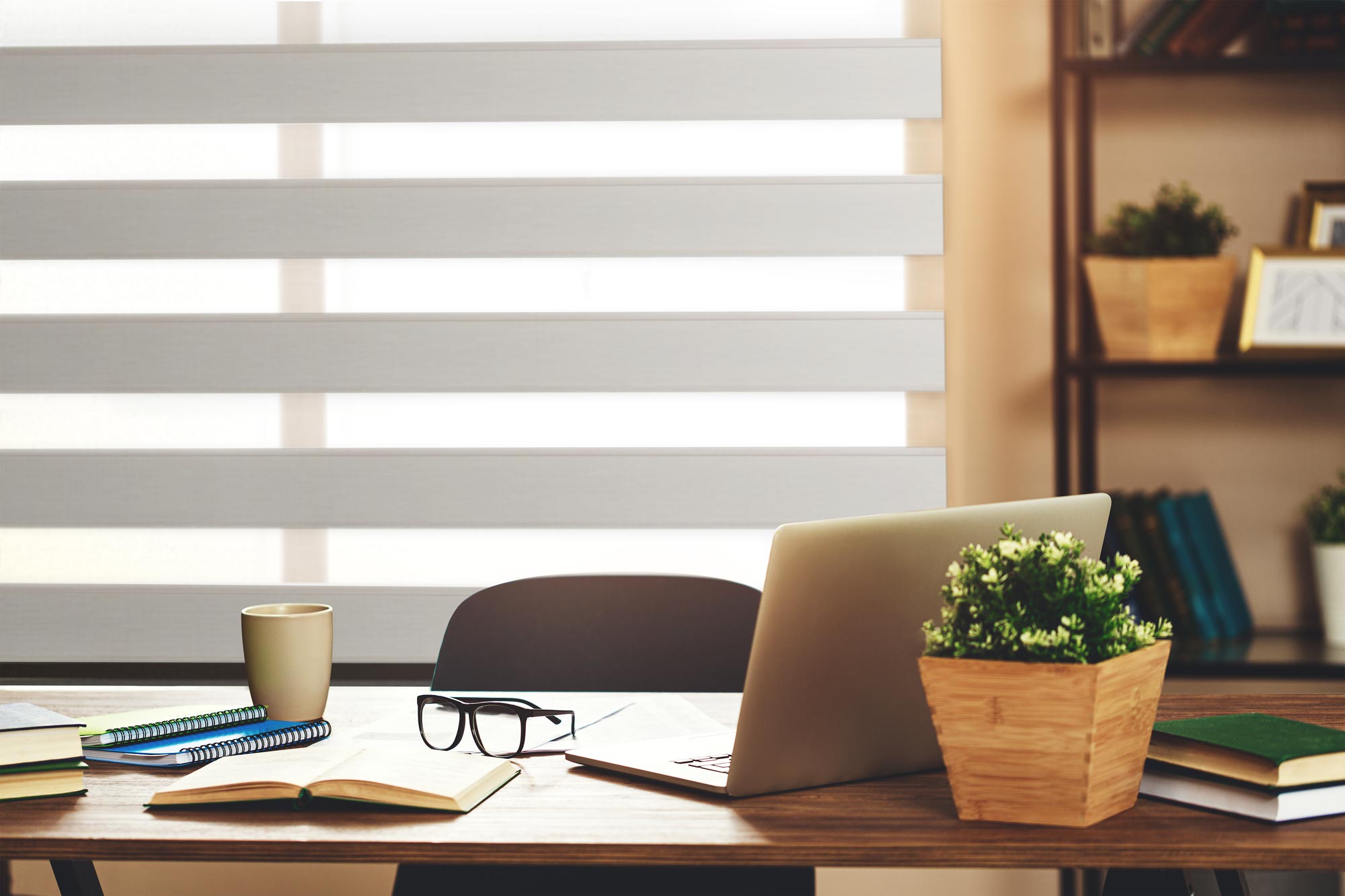 Closeup view of a tan Allure® Transitional Shades in an office with a desk and laptop in front