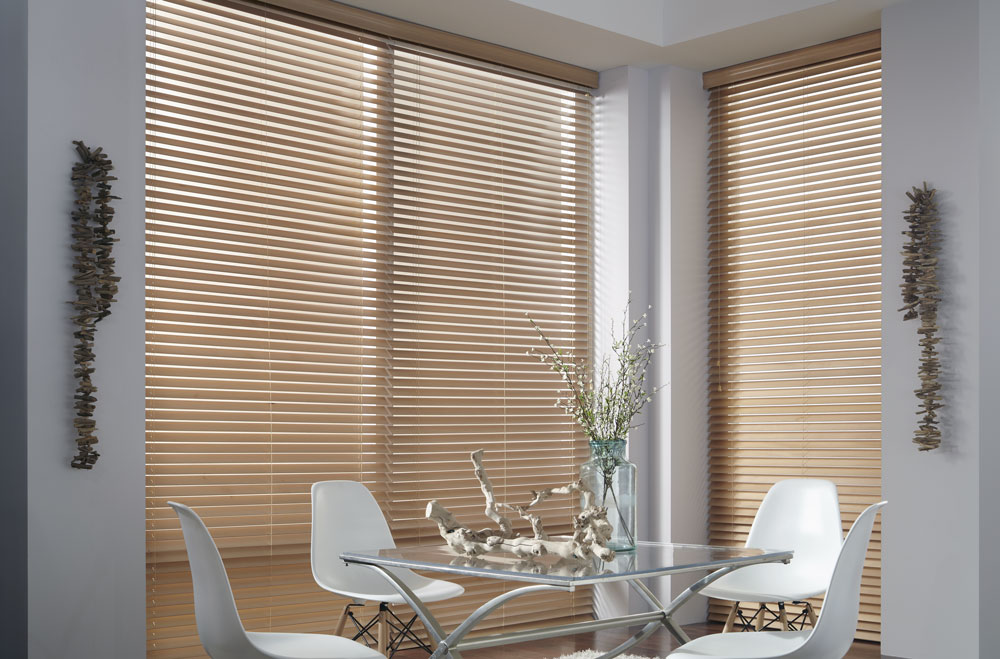 Large brown Heartland Woods® Wood Blinds in a dining room with a clear table and white chairs