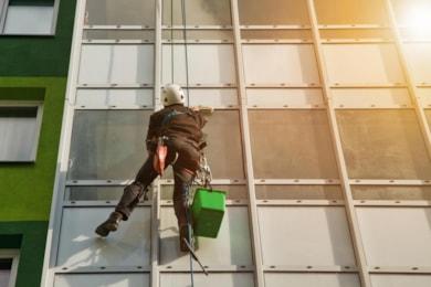 industrial-mountaineering-worker-uniform-washing-exterior-glazing-residential-facade-building