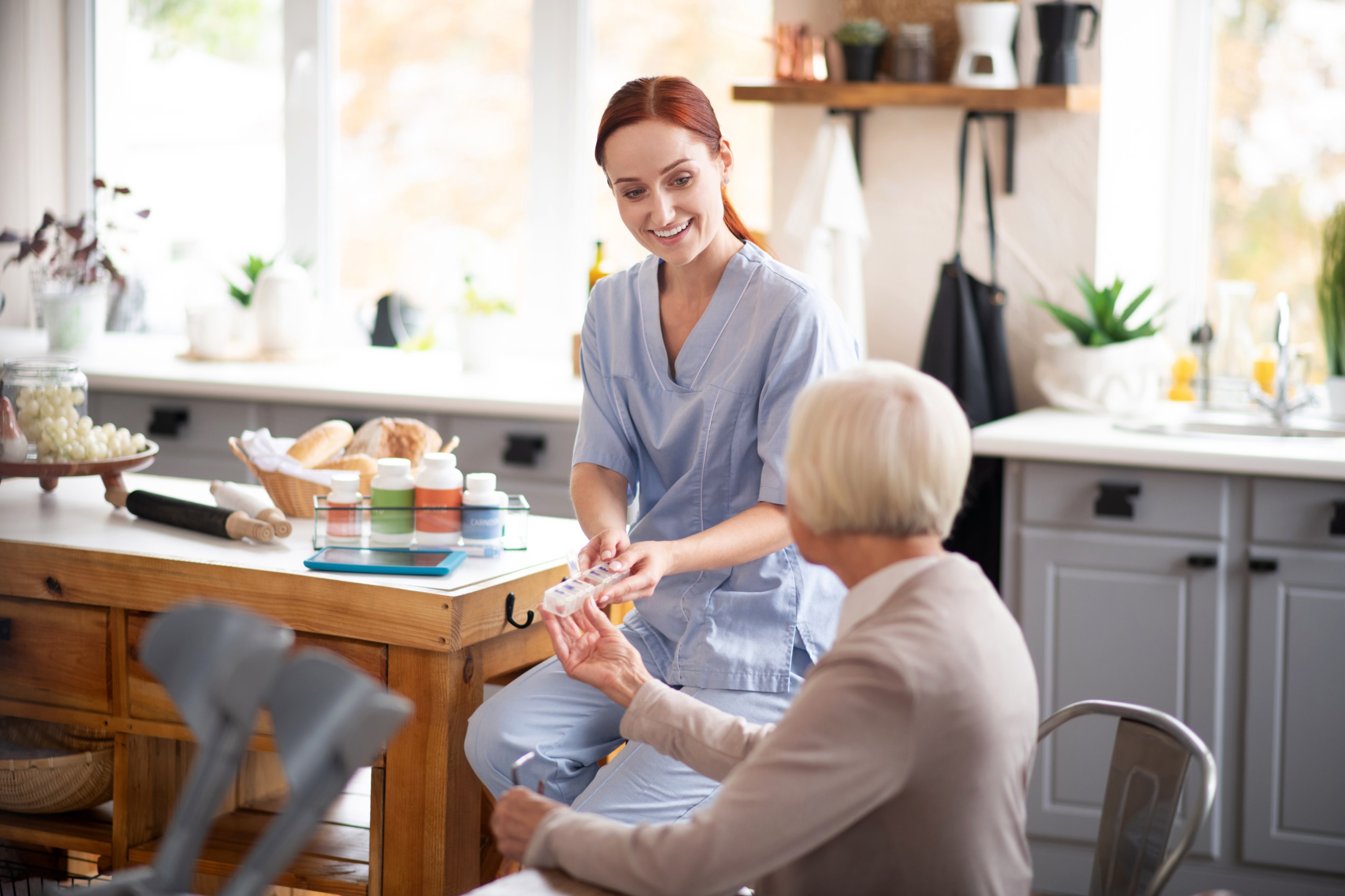 grey-haired-aged-woman-taking-pills-from-caregiver