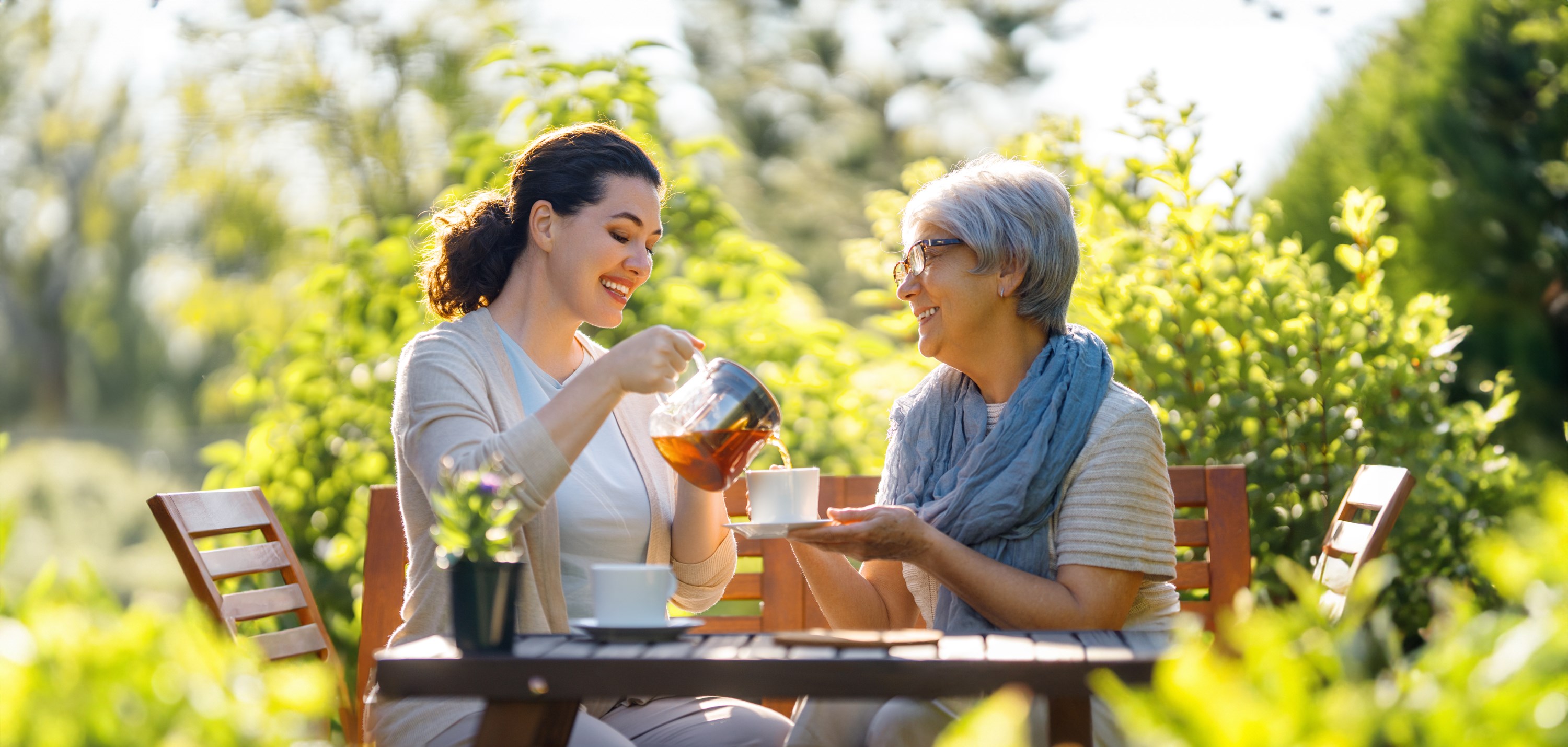 happy-young-woman-her-mother-drinking-tea-summer-morning-family-sitting-garden