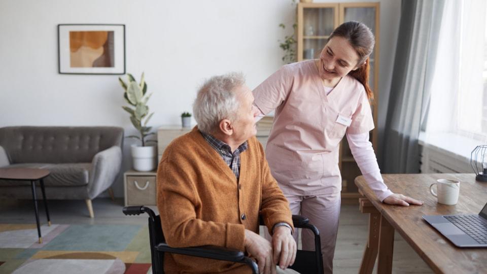 portrait-smiling-female-nurse-helping-senior-man-wheelchair-retirement-home-copy-space