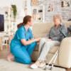 young-female-nurse-wearing-blue-uniform-talking-with-senior-woman-nursing-home