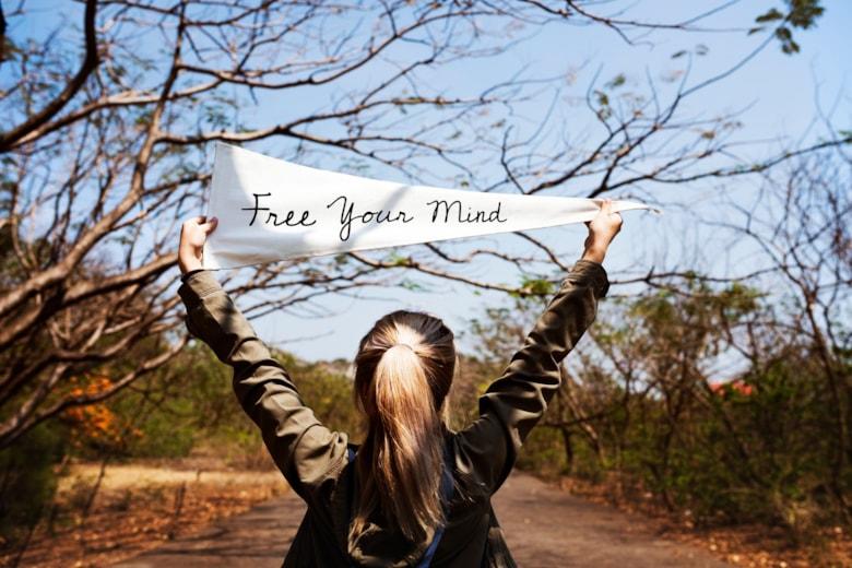 girl-holding-free-your-mind-flag-banner_53876-138129