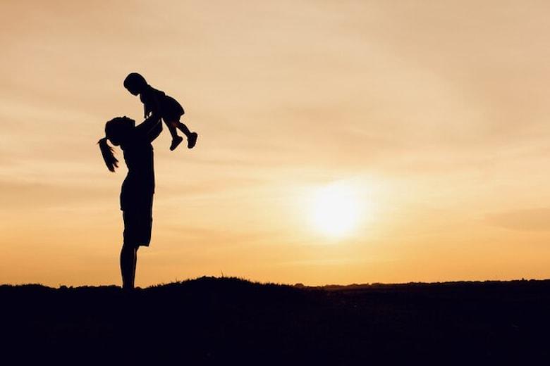silhouette-mother-daughter-lifting-child-air-scenic-sunset-sky-riverside_9635-603