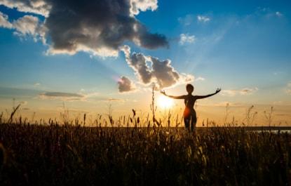 silhouette-sportive-girl-practicing-yoga-field-sunrise_176420-5190