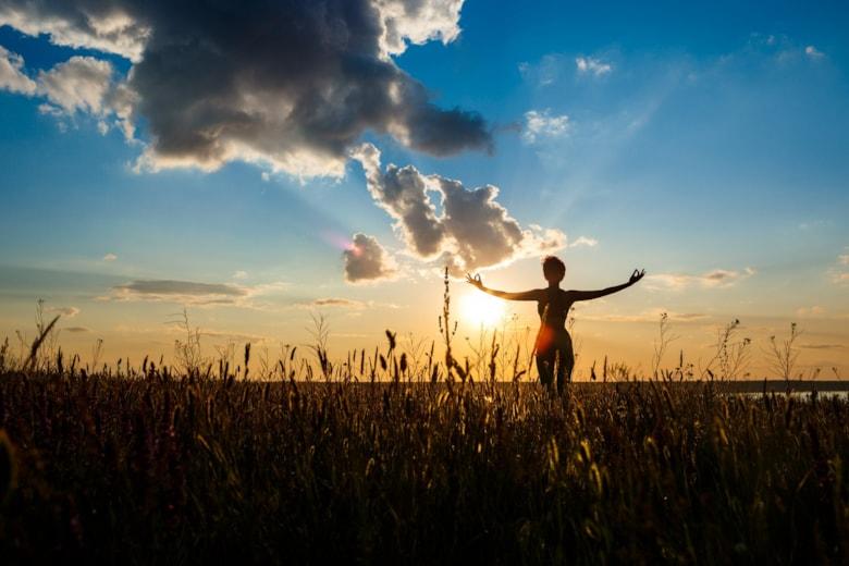 silhouette-sportive-girl-practicing-yoga-field-sunrise_176420-5190