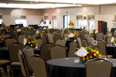 Corporate event held in The Ballroom at The Willows featuring petite colorful centerpieces